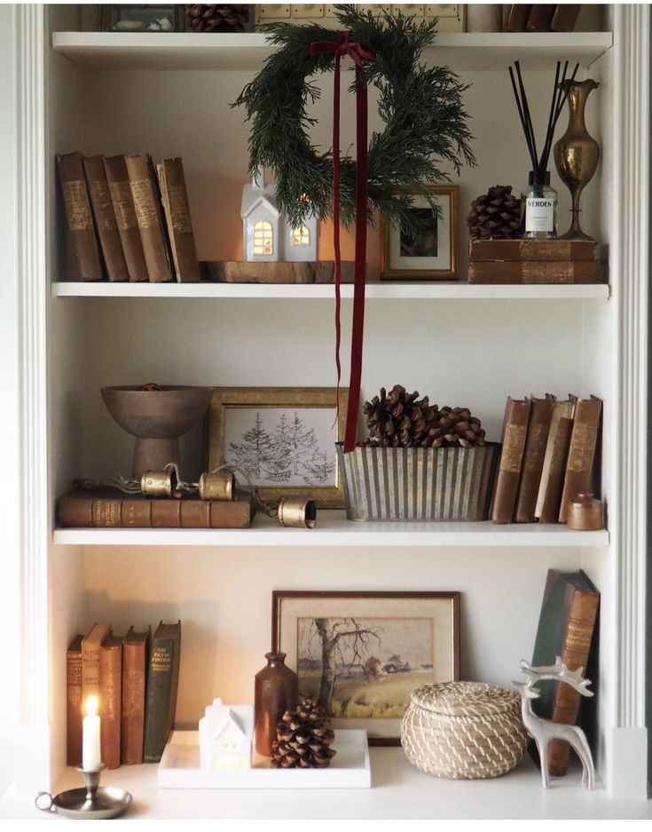 the shelves are filled with books and other christmas decorations, such as pine cone wreaths