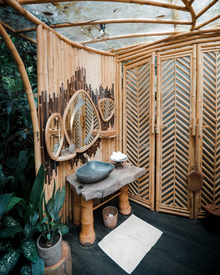 a bathroom with bamboo walls and flooring next to a plant filled area in the corner