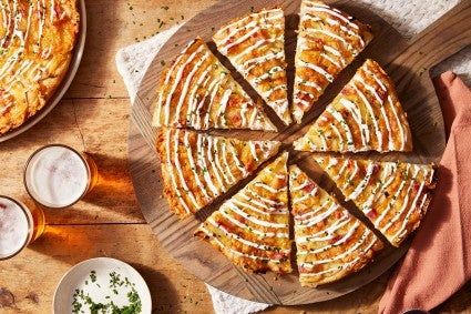 a pizza sitting on top of a wooden table next to two plates with slices missing