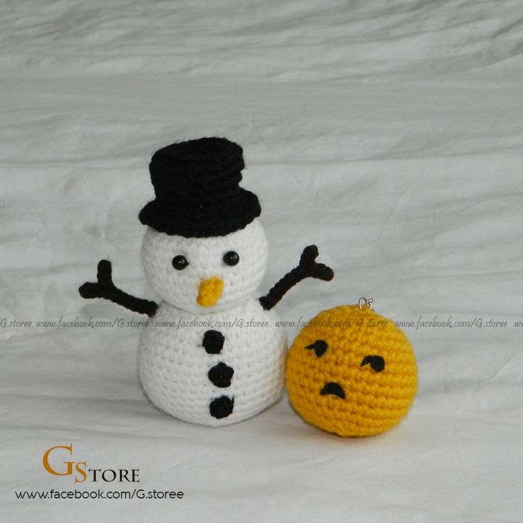 a small crocheted snowman next to an orange