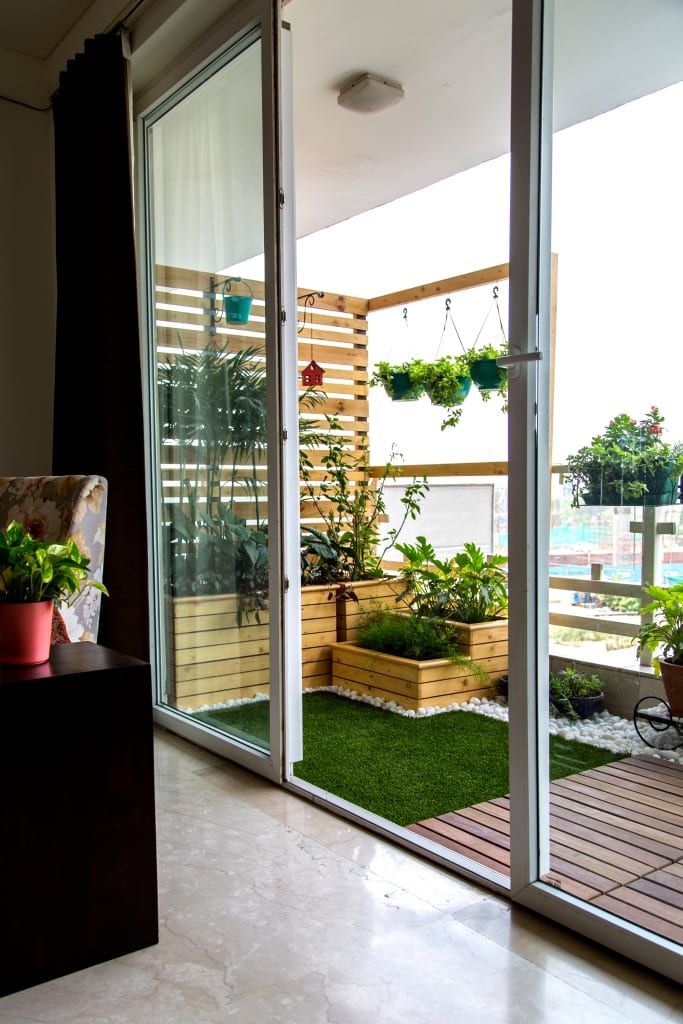 an instagram photo of a balcony with potted plants on the floor and sliding glass doors