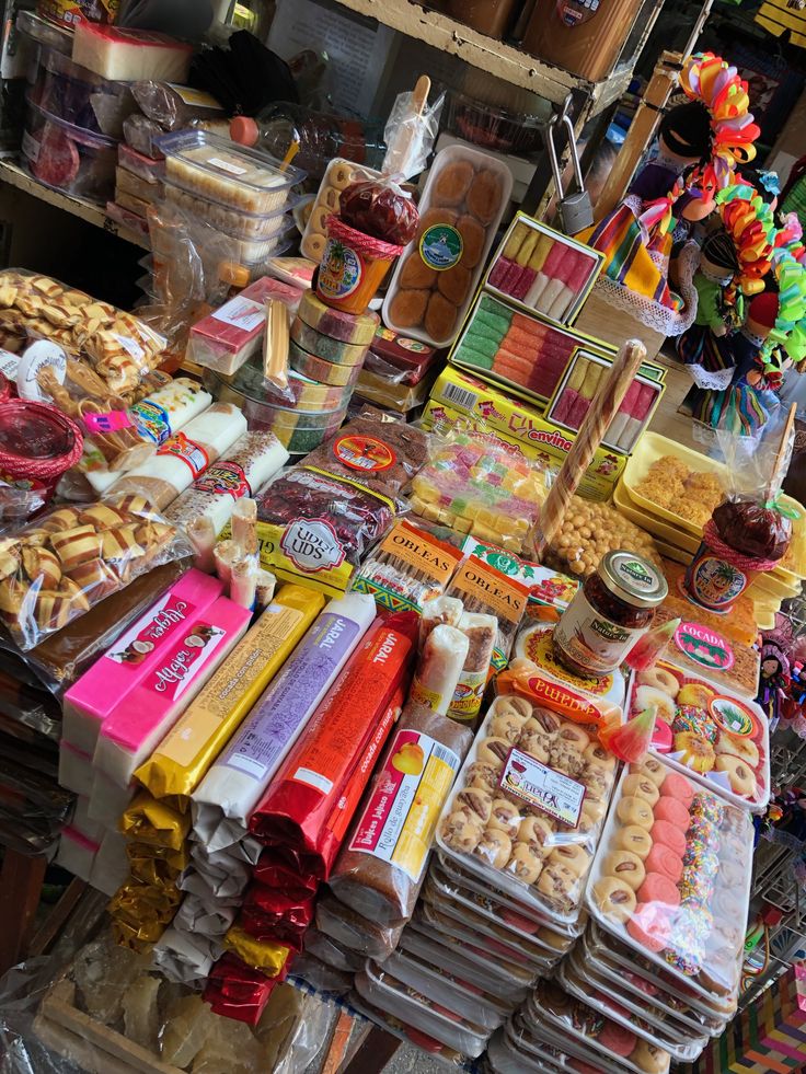 an assortment of food items on display at a market stall, including donuts, crackers, and more