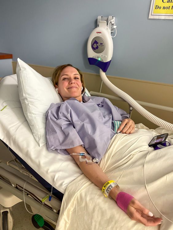 a woman laying in a hospital bed with an oxygen tube attached to the wall behind her