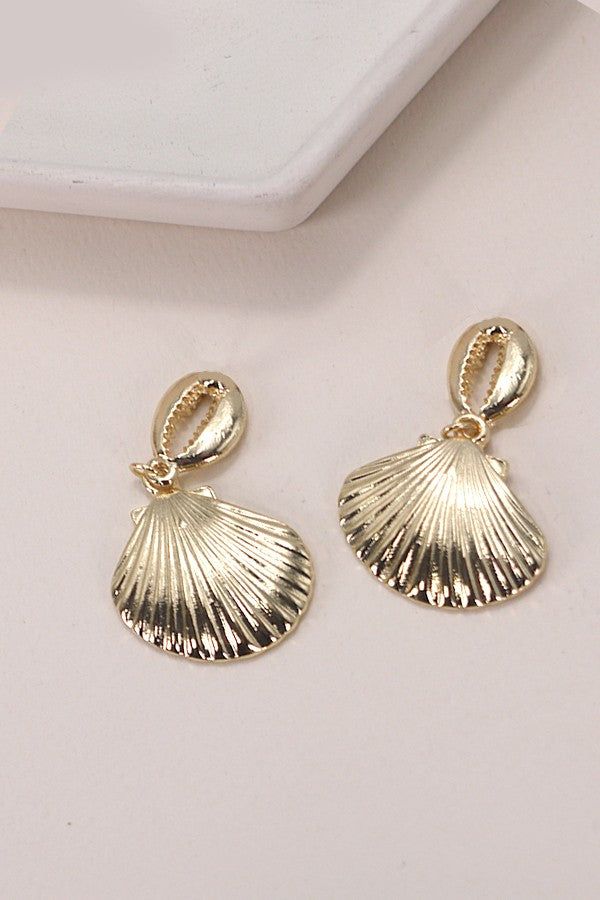 Gold Puka Seashell Drop Earrings, a stunning accessory that embodies coastal elegance. These earrings feature delicately crafted gold puka seashells, creating a chic and timeless design that seamlessly complements a variety of looks. Perfect for adding a touch of seaside allure to your ensemble, the Gold Puka Seashell Drop Earrings are versatile enough for both casual outings and more formal occasions.Product details:length: 1.5"width: 1" earring back: Postmetal finish: gold Platingproduct: Lead Gold Dangle Shell Earrings, Gold Shell Dangle Earrings, Gold Plated Shell-shaped Earrings, Gold Shell Drop Earrings, Ocean-inspired, Gold Ocean-inspired Shell Drop Earrings, Elegant Gold Dangle Shell Earrings, Elegant Gold Dangle Shell, Elegant Gold-tone Beach Jewelry, Elegant Gold-tone Jewelry For Beach