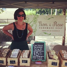 a woman standing in front of a table full of soaps