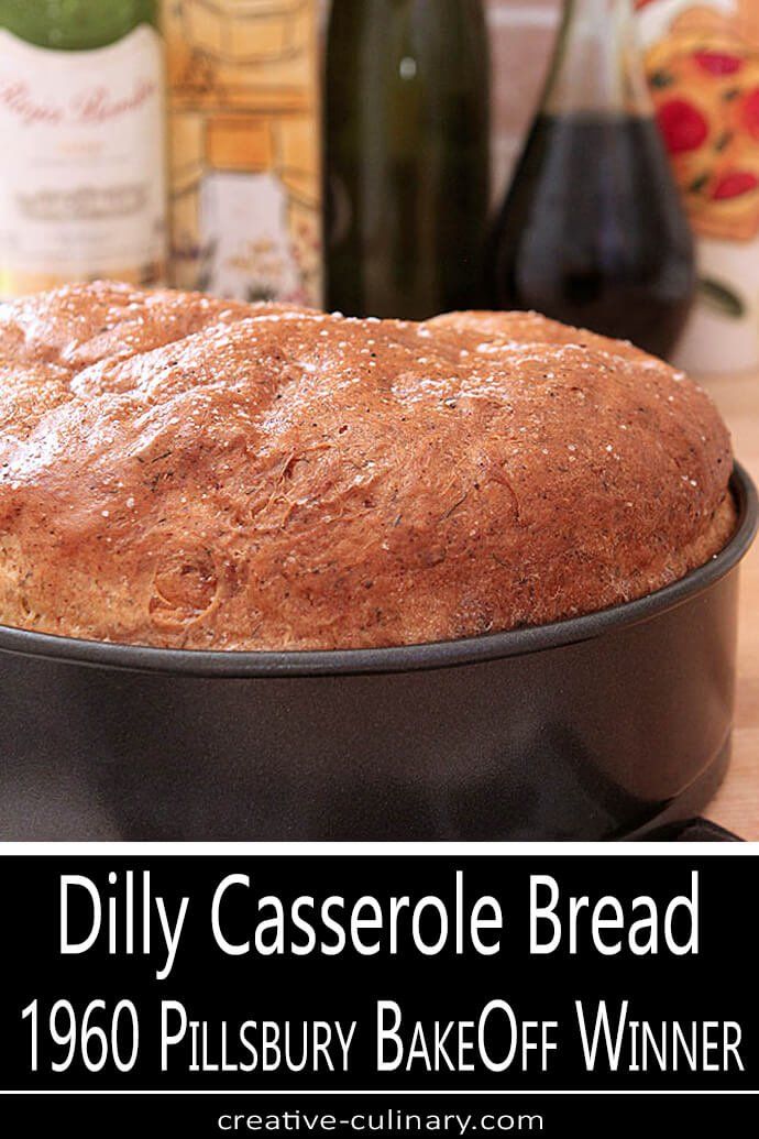 a loaf of bread sitting in a pan on top of a table next to wine bottles