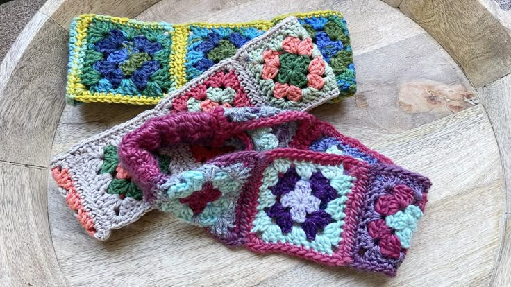 three crocheted grannys sitting on top of a wooden table