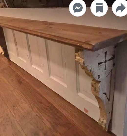 an old wooden bench sitting on top of a hard wood floor next to a white door