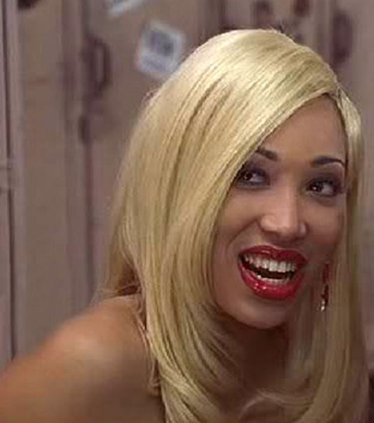 a woman with blonde hair smiling and wearing red lipstick on her lips is looking at the camera