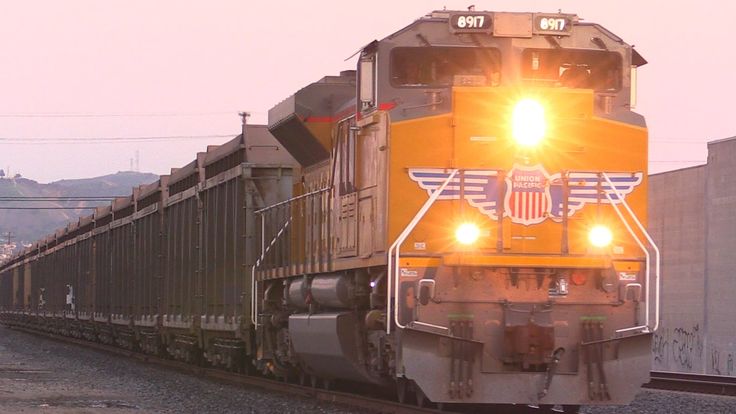 a train is traveling down the tracks with its lights on