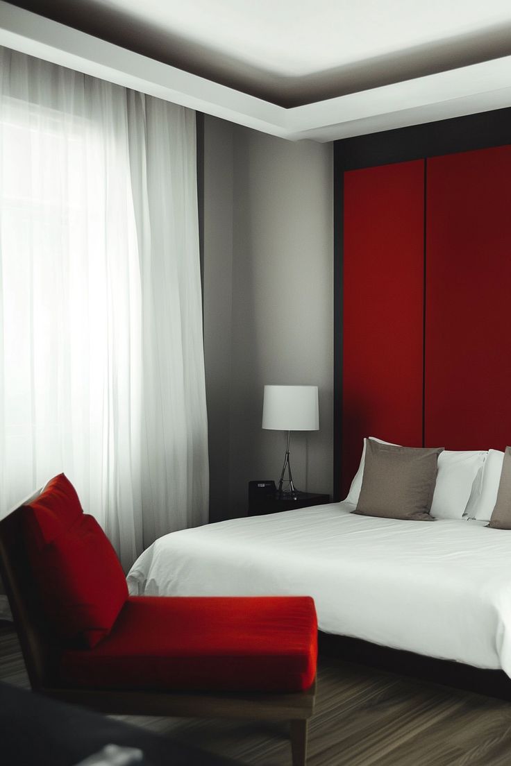 a bedroom with a red headboard and white bedspread on the bed is shown