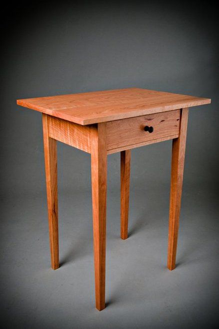 a small wooden table sitting on top of a gray floor