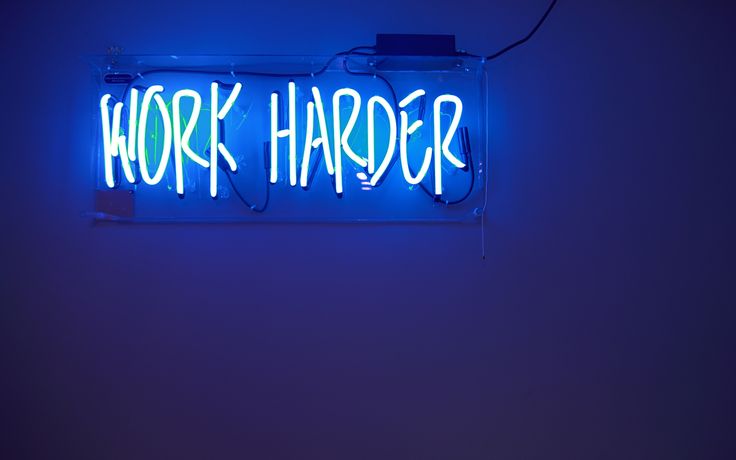 a neon sign that says work harder on it