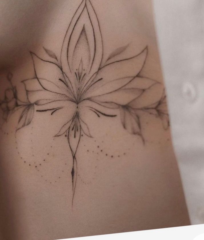 a woman's stomach with a flower tattoo on it