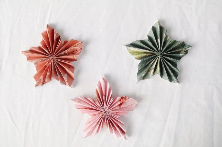 three origami flowers on a white sheet