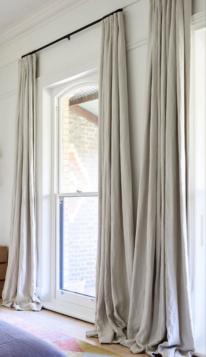 the curtains are pulled back in front of the window to let light into the room