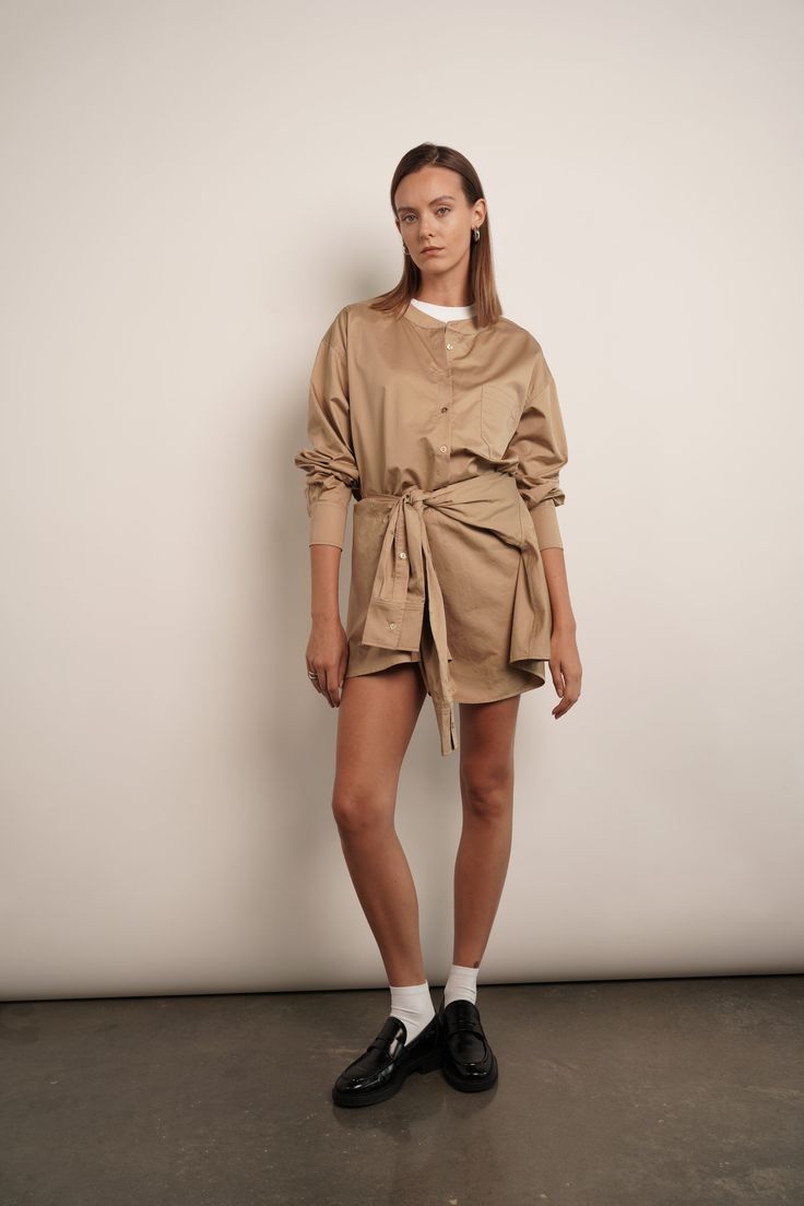 The Sierra shirt dress is effortlessly chic. It's made from crisp cotton-poplin with a loosely draped top and close-fitting mini skirt. Unbutton the collar to create a more relaxed look. Dress is designed to look like a deconstructed shirt worn back to front. Detailed with buttons along the reverse, it's cut from cotton-poplin and has a loose shape tempered by ties at the waist meant to resemble a second pair of sleeves. 100% Cotton Chic Oversized Collared Shirt Dress, Chic Fall Shirt Dress With Shirttail Hem, Fall Relaxed Fit Mini Shirt Dress, Chic Oversized Shirt Dress With Shirttail Hem, Chic Oversized Shirt Dress With Spread Collar, Relaxed Fit Mini Shirt Dress For Fall, Relaxed Fit Mini Shirt Dress For Work, Beige Mini Shirt Dress For Work, Beige Relaxed Fit Shirt Dress For Fall