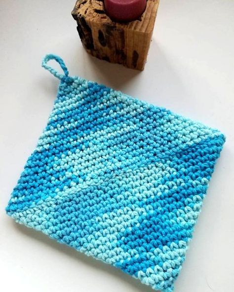 a blue and white crochet bag next to a rubber stamp on a table