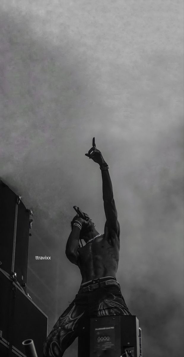 a man standing on top of a stage holding his arm in the air