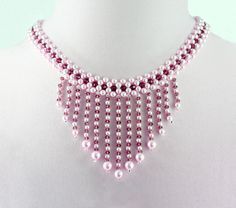 a pink beaded necklace on a white mannequin