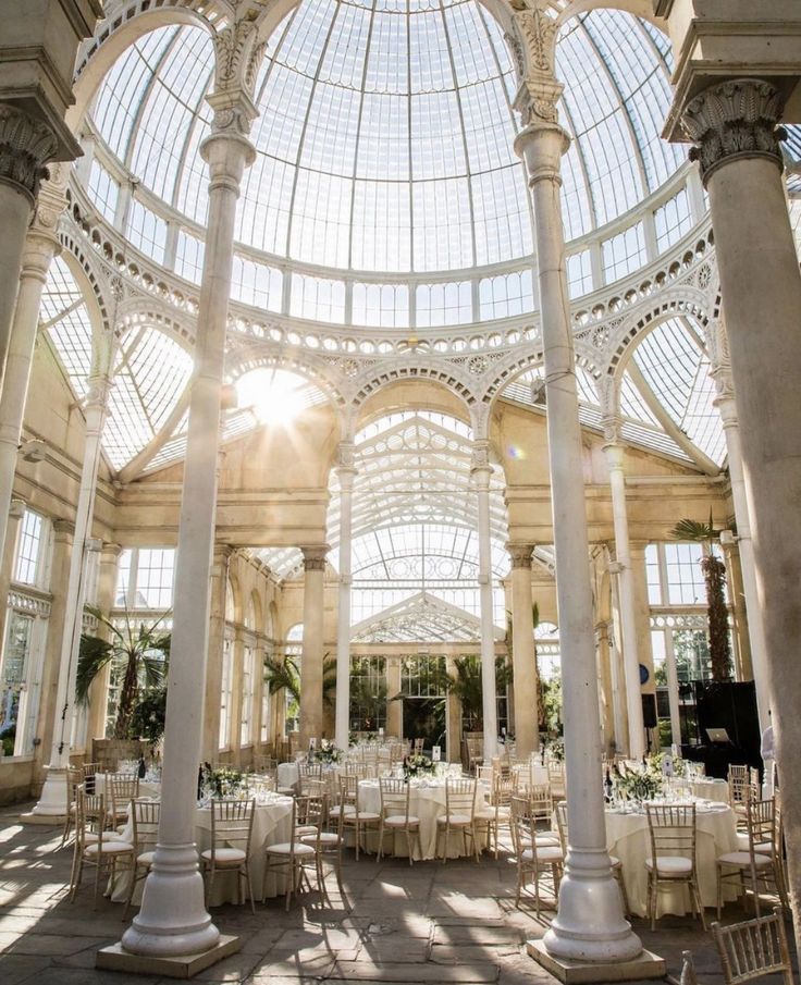 the inside of a building with tables and chairs set up for a formal function in it