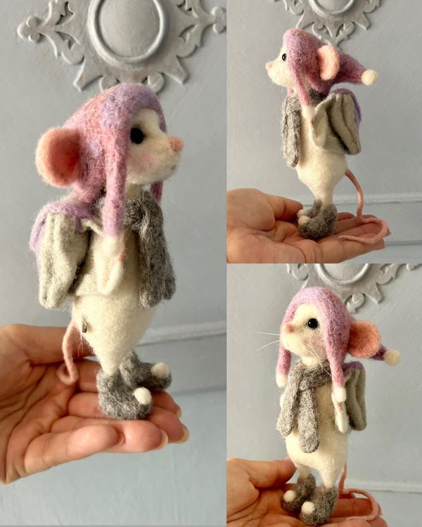 the stuffed animal mouse is wearing a pink and gray hat with ears, tail, and feet