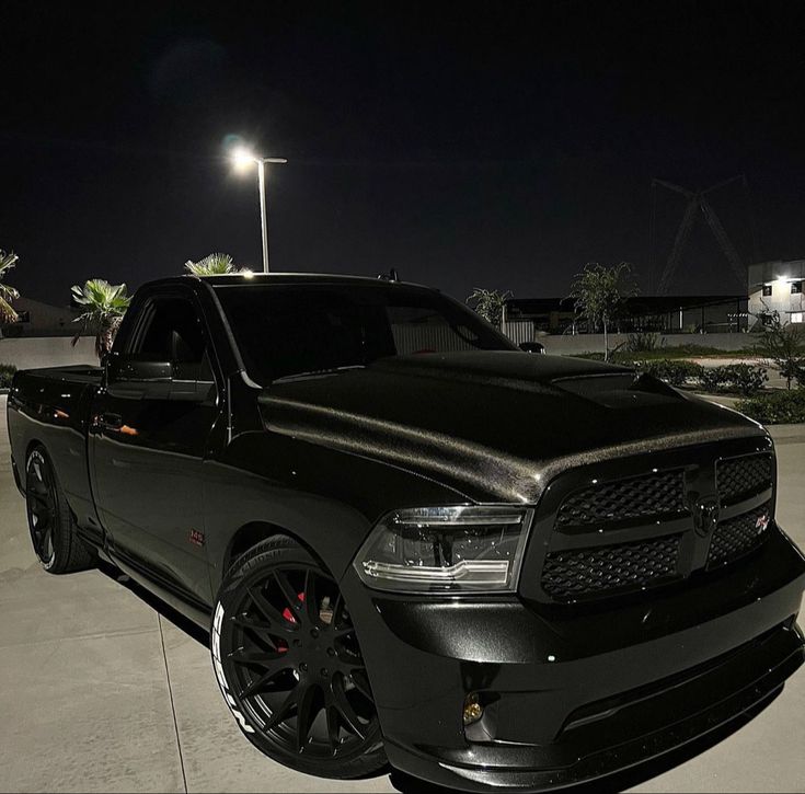 a black truck parked in a parking lot at night