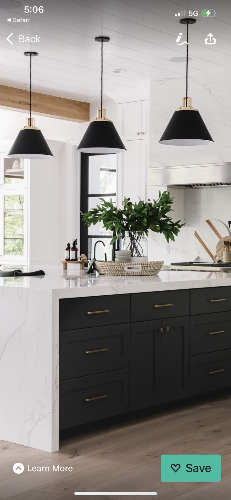 a kitchen with marble counter tops and black pendant lights