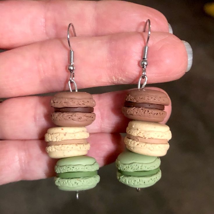 a pair of earrings that are shaped like macaroni and cheesecakes with chocolate frosting on them