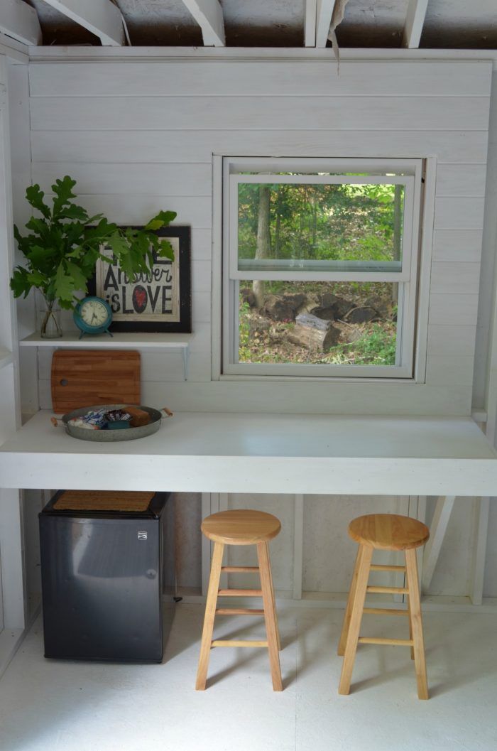 two stools sit in front of a window on a shelf above a trash can