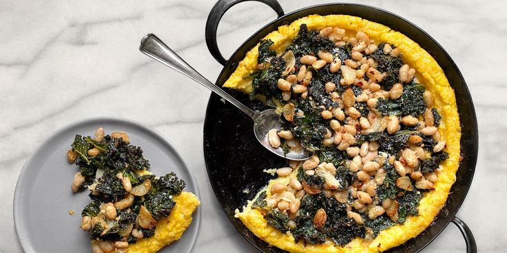 an omelet with spinach and chickpeas on top is served in a black pan