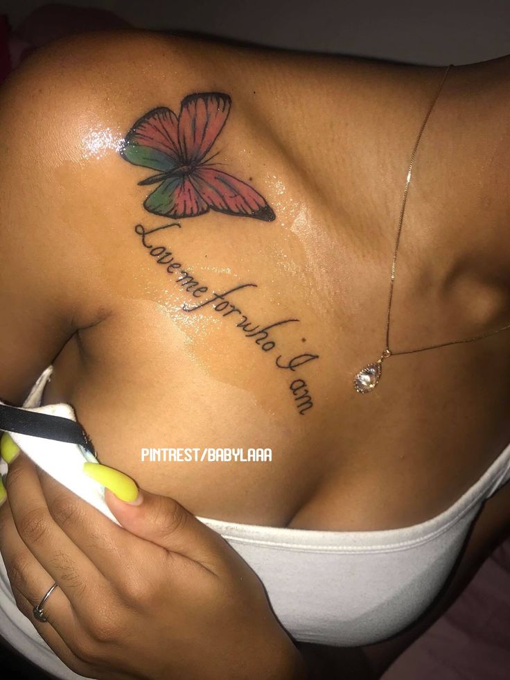 a woman with a butterfly tattoo on her chest holding a pair of scissors in her hand