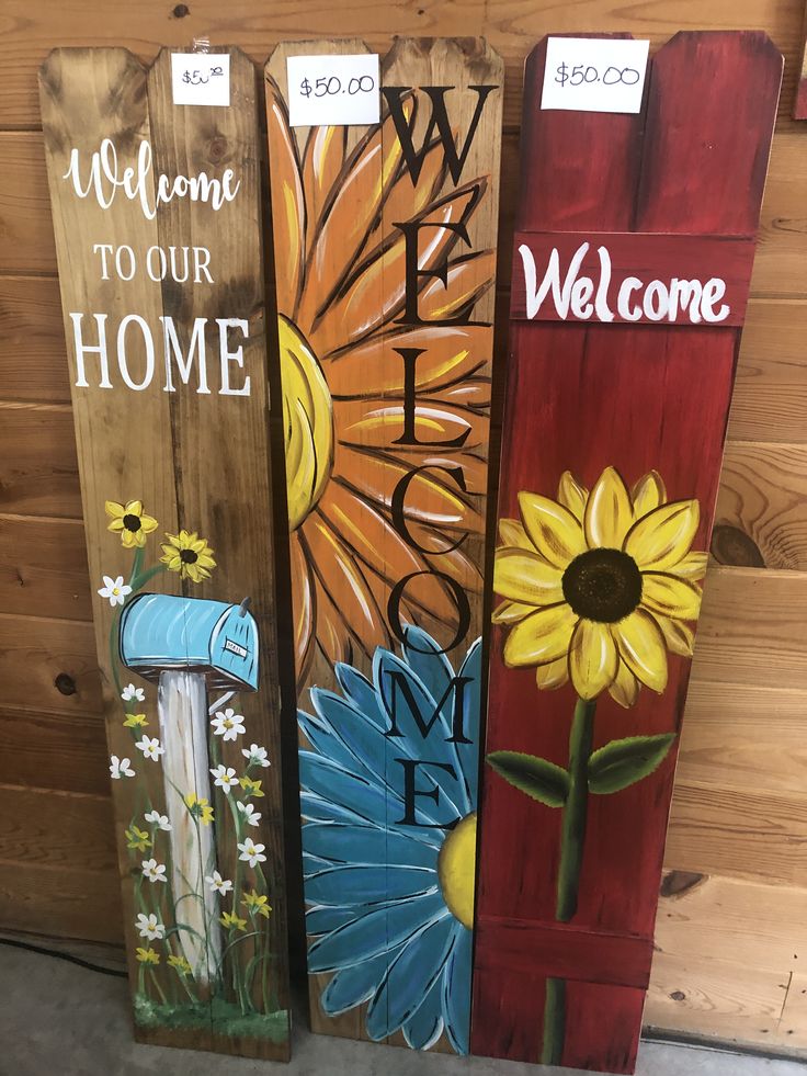 three wooden signs with flowers painted on them and the words welcome to our home are shown