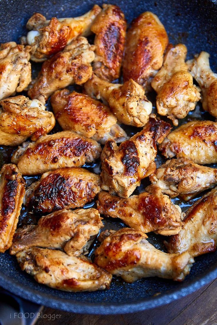 chicken wings cooking in a skillet ready to be cooked