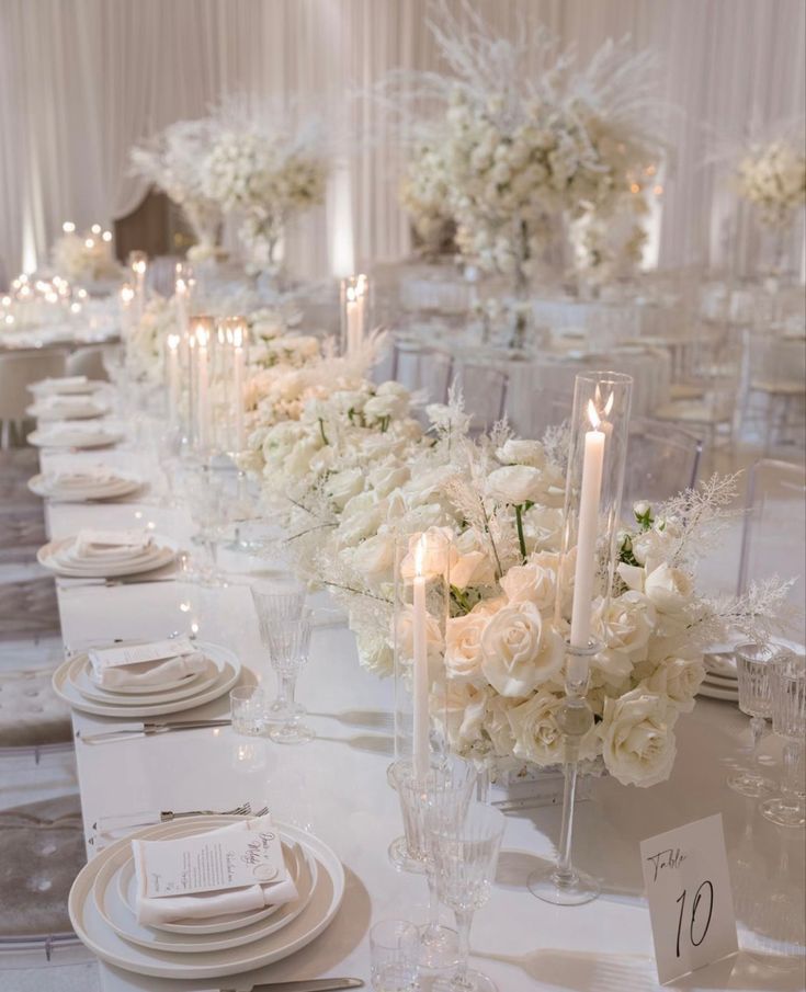 a long table with white flowers and candles