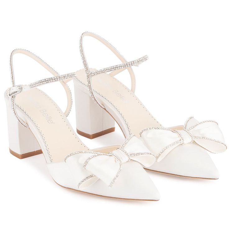 a pair of white shoes with bows on them