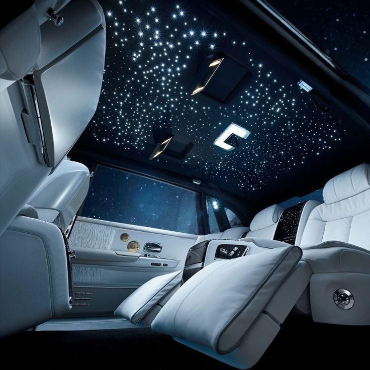 the interior of a limo with white leather seats and stars in the sky on the ceiling