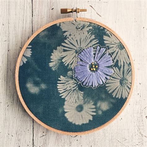 a blue and white flower on a wooden hoop