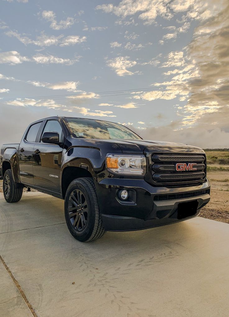 the black truck is parked on the concrete