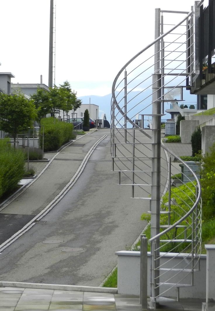 a curved metal staircase next to an empty street