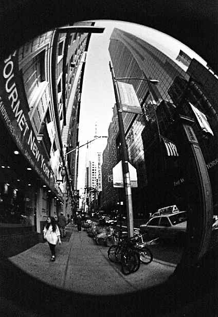 a person walking down a street next to tall buildings