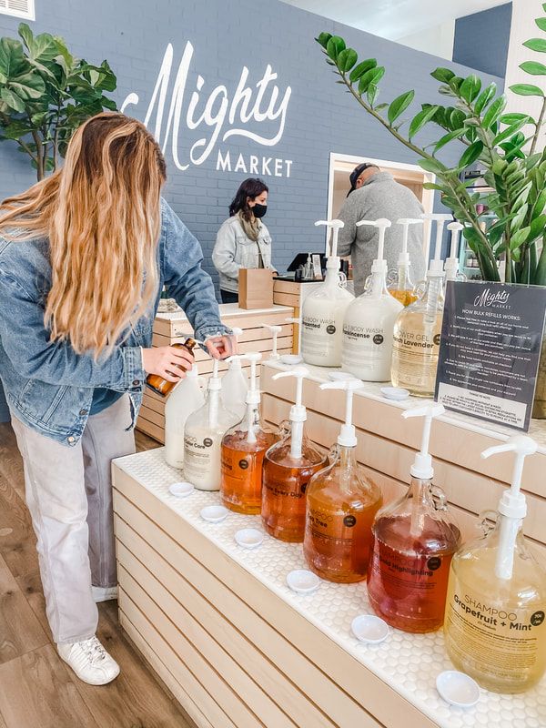 a woman standing in front of bottles of liquid