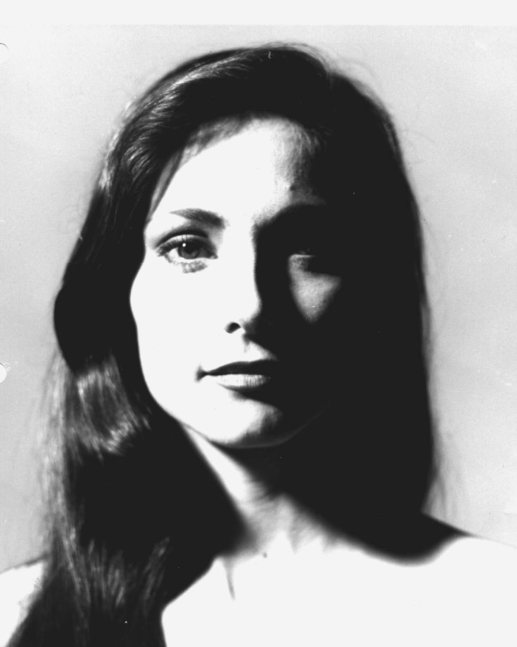 an old black and white photo of a woman with long hair