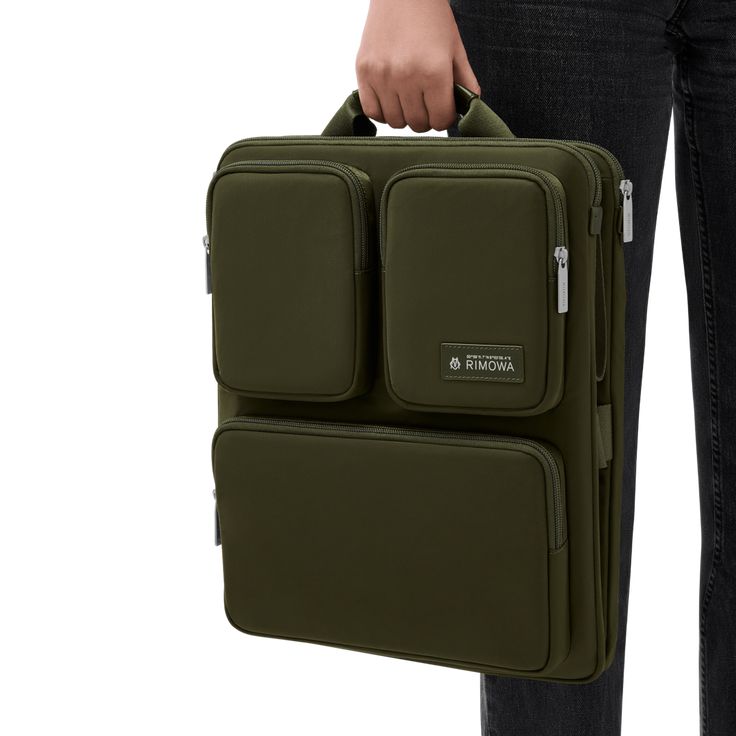 Crafted from high-quality nylon, the RIMOWA Cabin Luggage Harness in Khaki green streamlines the experience of traveling with hand luggage. Conveniently secured to your RIMOWA Cabin suitcase using adjustable straps, it boasts a clever formation of pockets and compartments that offer easy access to your essentials such as phones, electronics and toiletry pouches. Two large zipped pockets can each fit a laptop of up to 16" in size, or documents and magazines. The Luggage Harness is designed to fit the RIMOWA Original, Classic, Essential, Essential Lite and Hybrid suitcases in the following sizes only: Cabin U, Cabin S, Cabin and Cabin Plus. Rimowa Cabin, Leather Office Bags, Leather Front Pocket Wallet, Cabin Suitcase, Cabin Luggage, Diy Bag Designs, Green Travel, Office Bag, Diy Tote Bag