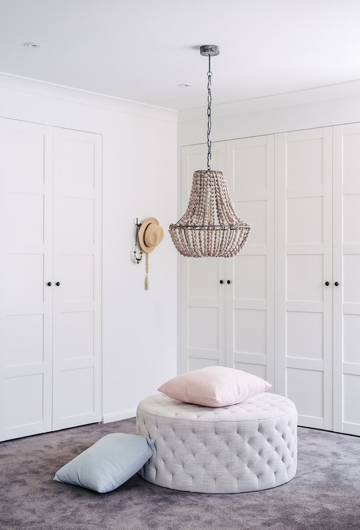 a bedroom with white closets and a chandelier hanging from the ceiling above it