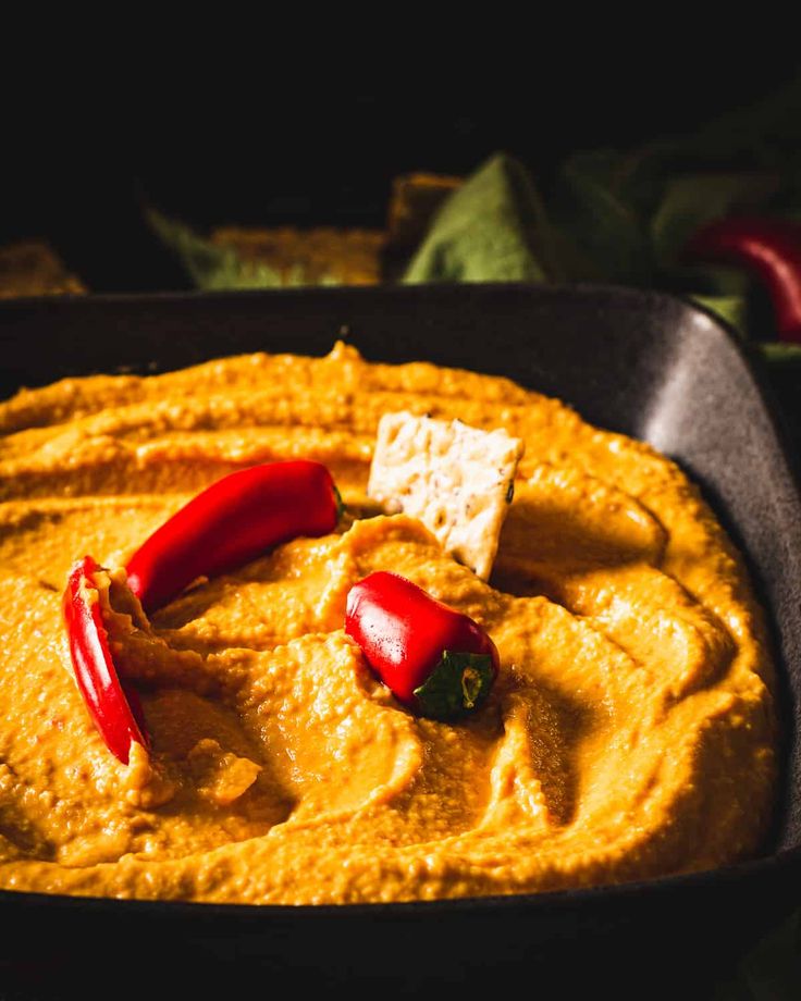 a pan filled with hummus and crackers