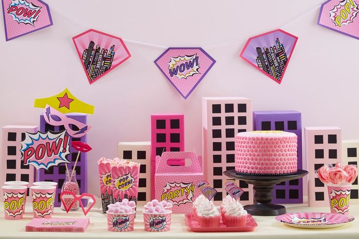 a table topped with lots of pink and purple decorations