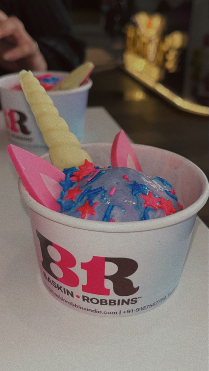 an ice cream with blue and red sprinkles in a cup