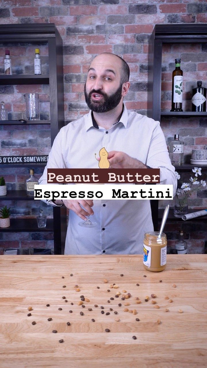 a man standing in front of a wooden table with lots of brown seeds on it