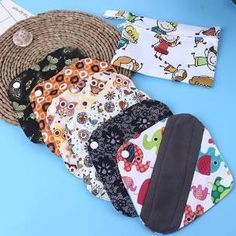 several different types of baby bibs laying on a table next to some straw hats